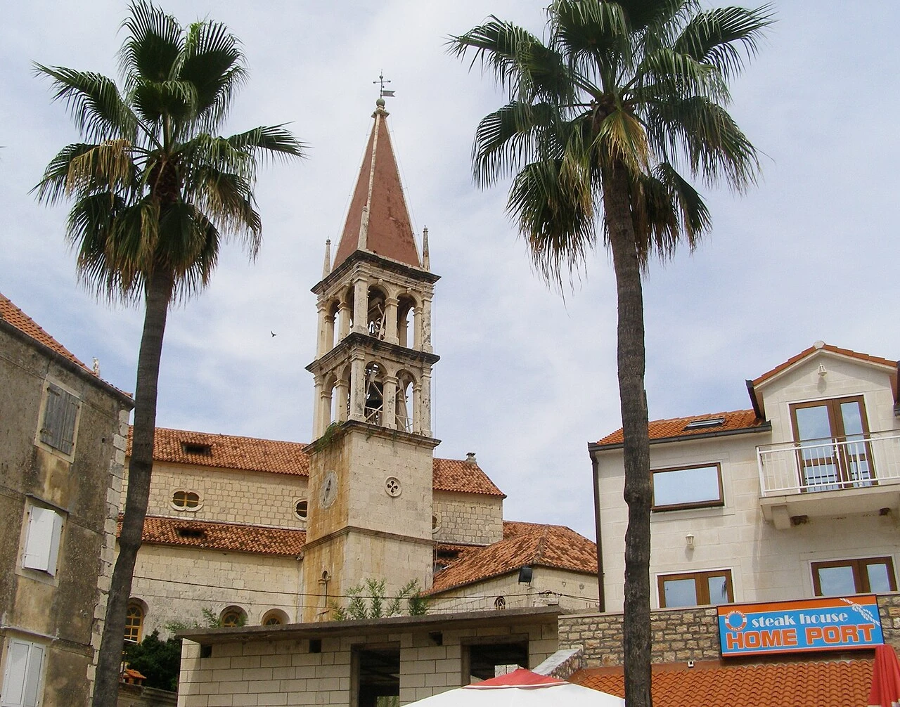 Pročelje crkve i palma u Milni na otoku Braču.